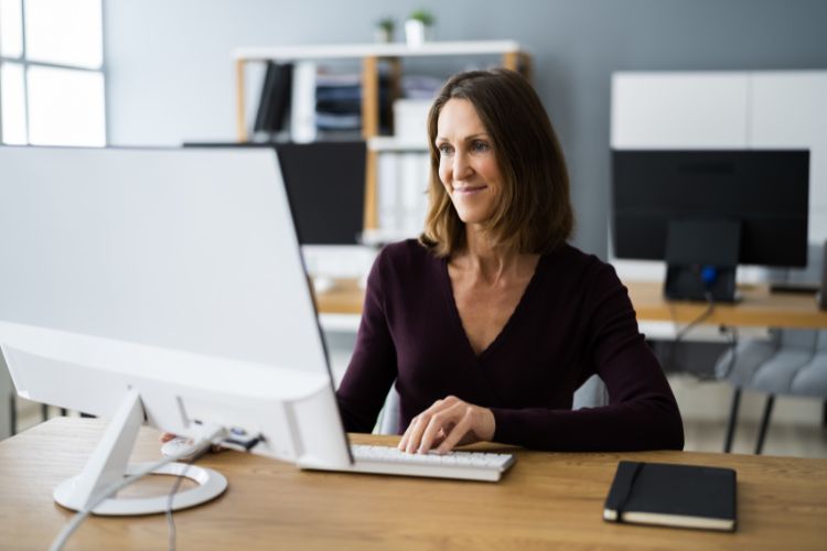 priority-management-smiling-at-computer